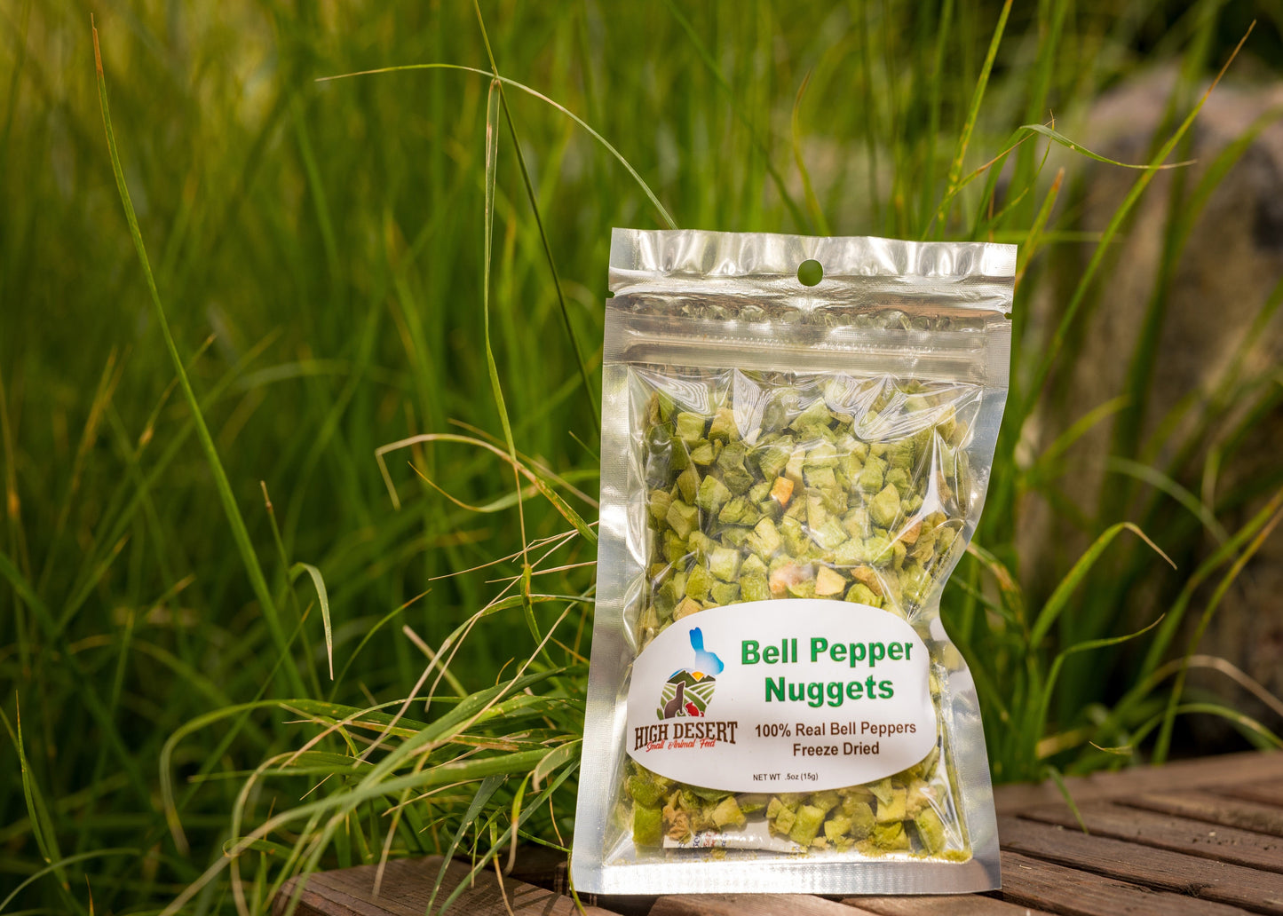 Packaged bell pepper nuggets on a wooden surface with grass in the background