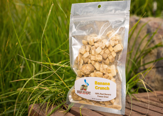 Packaged banana crunch snack with a label on grass