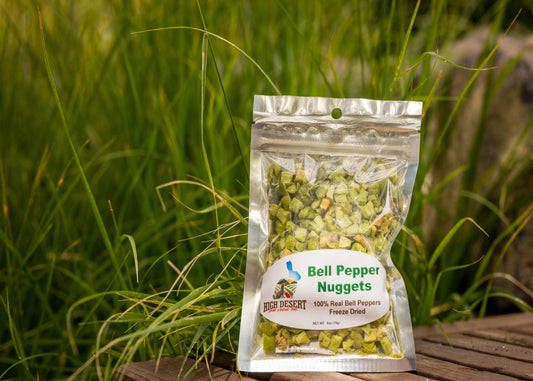 Packaged bell pepper nuggets on a wooden surface with grass in the background