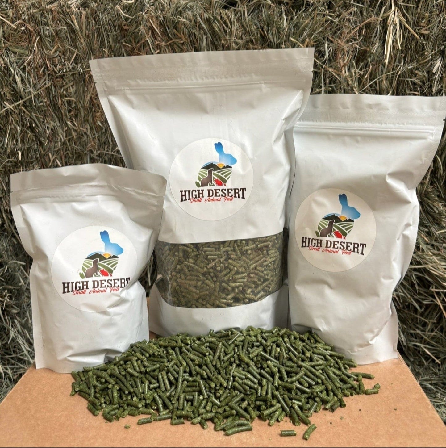 Three bags of High Desert products on a cardboard box with hay in the background