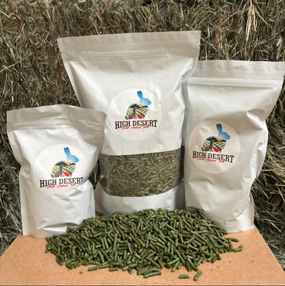 Three bags of High Desert products on a cardboard box with hay in the background