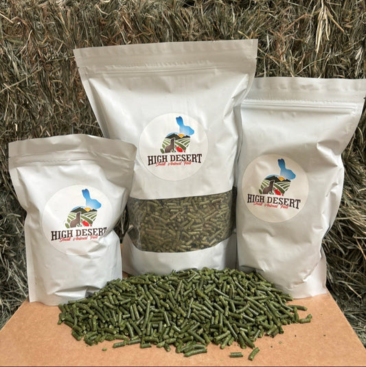 Three bags of High Desert products on a cardboard box with hay in the background