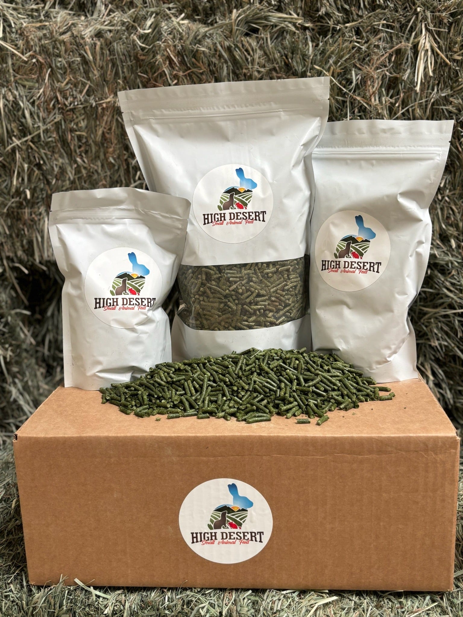 Bags of rabbit food on a box with hay background.