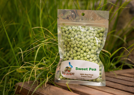 Packaged freeze-dried sweet peas on a wooden surface with grass in the background